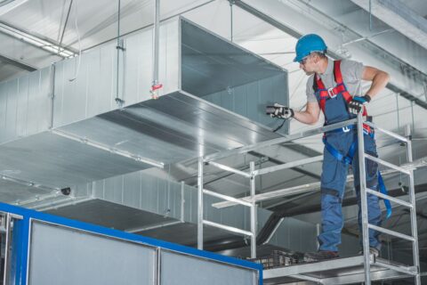Técnico revisando sistema de ventilación industrial en cocina profesional